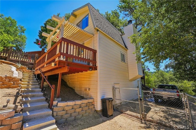 463 Delle Dr, Crestline, CA 92325 - view of home's exterior with a gate, a chimney, a wooden deck, stairway, and a shingled roof