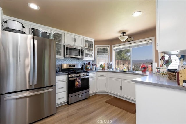 28219 Langside Ave, Canyon Country, CA 91351 - kitchen with stainless steel appliances, white cabinets, backsplash, glass insert cabinets, and recessed lighting