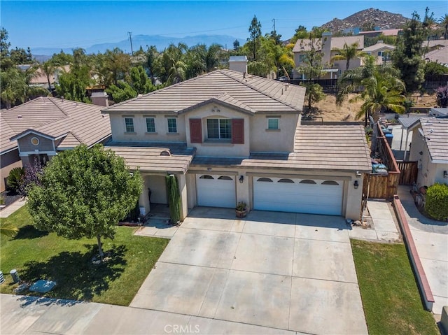 16074 Coyote Springs Ct, Moreno Valley, CA 92551 - traditional-style home with stucco siding, driveway, an attached garage, a tiled roof, and a residential view