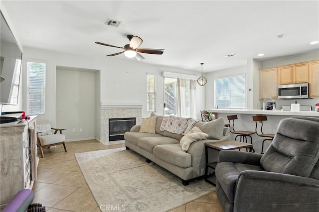 16074 Coyote Springs Ct, Moreno Valley, CA 92551 - living room with light tile patterned floors, healthy amount of natural light, ceiling fan, a tile fireplace, and recessed lighting