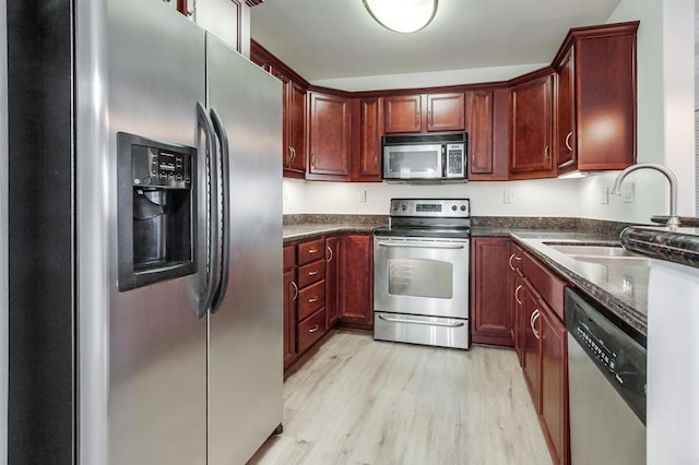 506 Canyon Dr Unit 70, Oceanside, CA 92054 - kitchen with appliances with stainless steel finishes, light wood-style floors, and dark brown cabinets