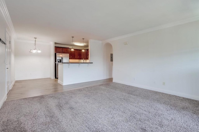 506 Canyon Dr Unit 70, Oceanside, CA 92054 - unfurnished living room with light carpet, crown molding, arched walkways, and a chandelier