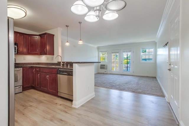 506 Canyon Dr Unit 70, Oceanside, CA 92054 - kitchen with stainless steel appliances, dark countertops, crown molding, open floor plan, and light wood-type flooring