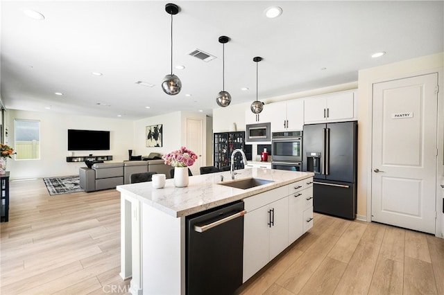28508 Daybreak Way, Saugus, CA 91350 - kitchen with high end refrigerator, dishwashing machine, stainless steel double oven, light wood finished floors, and a kitchen island with sink
