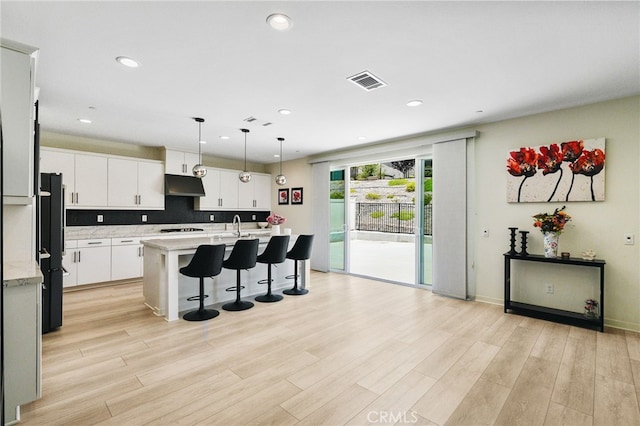 28508 Daybreak Way, Saugus, CA 91350 - kitchen featuring a kitchen breakfast bar, stovetop, light wood-style flooring, recessed lighting, and under cabinet range hood