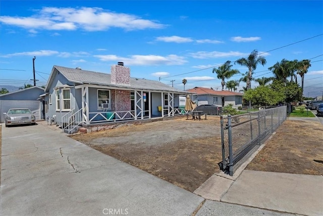 24976 7th St, San Bernardino, CA 92410 - view of front facade featuring covered porch, a chimney, and an outbuilding