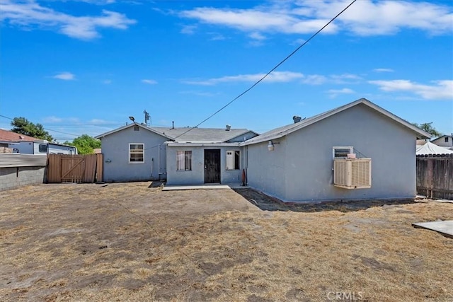 24976 7th St, San Bernardino, CA 92410 - rear view of house with stucco siding and a gate