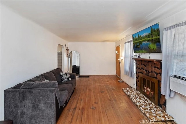 24976 7th St, San Bernardino, CA 92410 - living room featuring arched walkways, wood-type flooring, and a fireplace
