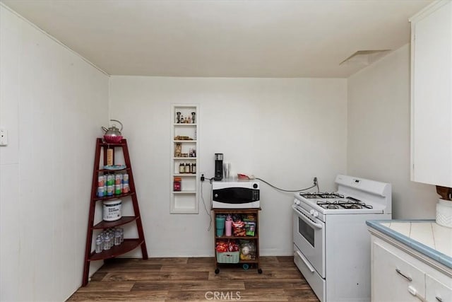 24976 7th St, San Bernardino, CA 92410 - kitchen with white appliances, dark wood finished floors, tile countertops, and white cabinetry