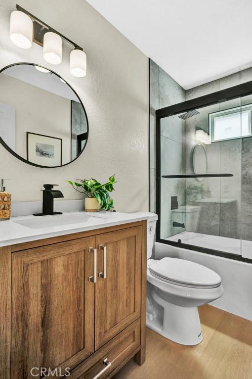 10965 Canis Ln, San Diego, CA 92126 - full bath featuring vanity, wood finished floors, and combined bath / shower with glass door
