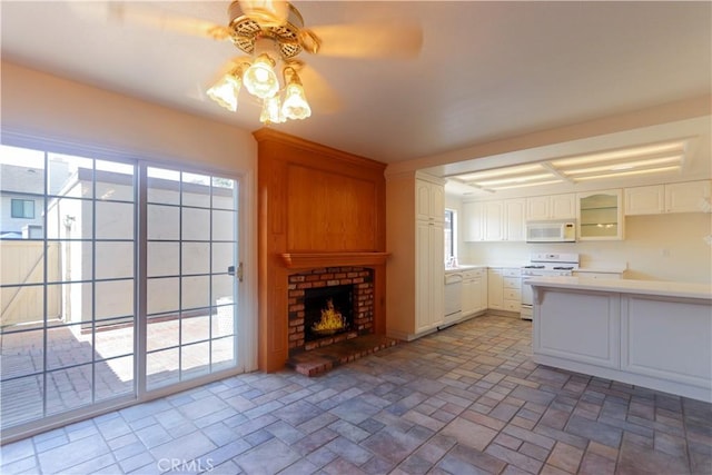 227 Gable Ln, La Habra, CA 90631 - kitchen featuring white appliances, ceiling fan, a fireplace, light countertops, and white cabinets