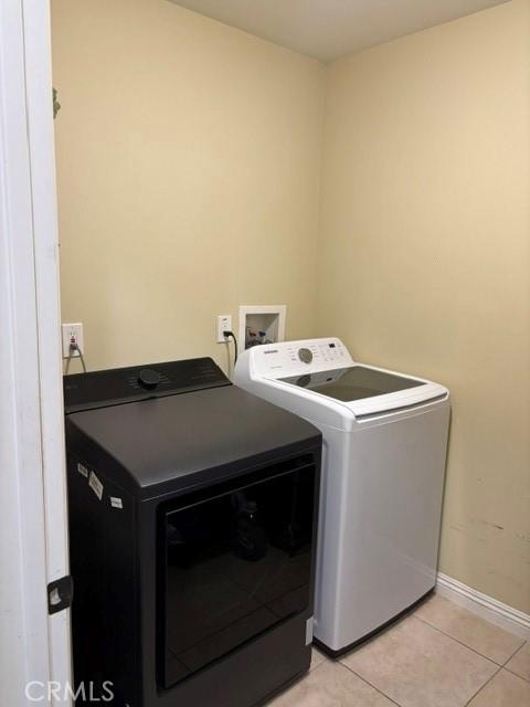 10401 Hemlock Ave, Hesperia, CA 92345 - laundry area with washing machine and dryer and light tile patterned floors
