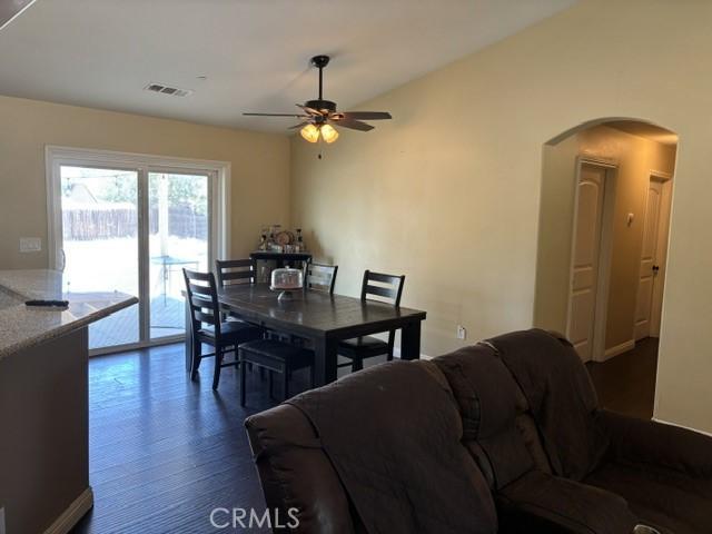 10401 Hemlock Ave, Hesperia, CA 92345 - dining room with arched walkways, ceiling fan, and dark wood finished floors