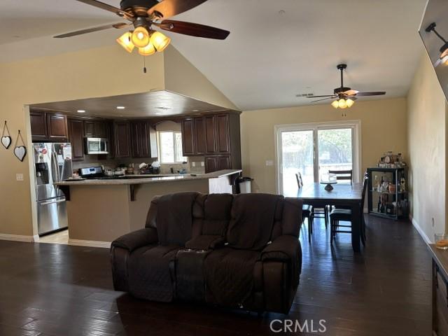 10401 Hemlock Ave, Hesperia, CA 92345 - living area featuring a ceiling fan, wood finished floors, and high vaulted ceiling