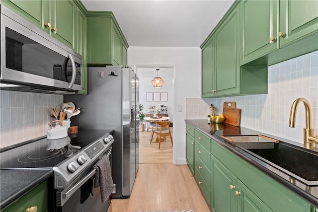 625 N Flores St Unit 202, West Hollywood, CA 90048 - kitchen featuring stainless steel appliances, green cabinetry, light wood-type flooring, and decorative backsplash