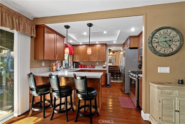 2566 Cottonwood Trl, Chino Hills, CA 91709 - kitchen featuring stainless steel appliances, a peninsula, dark wood-type flooring, light countertops, and ornamental molding