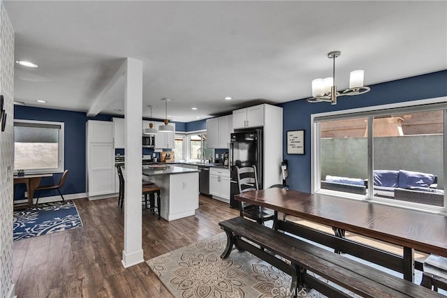 3609 S Parton St, Santa Ana, CA 92707 - kitchen with appliances with stainless steel finishes, dark countertops, a chandelier, white cabinets, and a kitchen breakfast bar