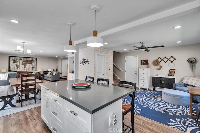 3609 S Parton St, Santa Ana, CA 92707 - kitchen with open floor plan, dark countertops, wood finished floors, white cabinets, and recessed lighting
