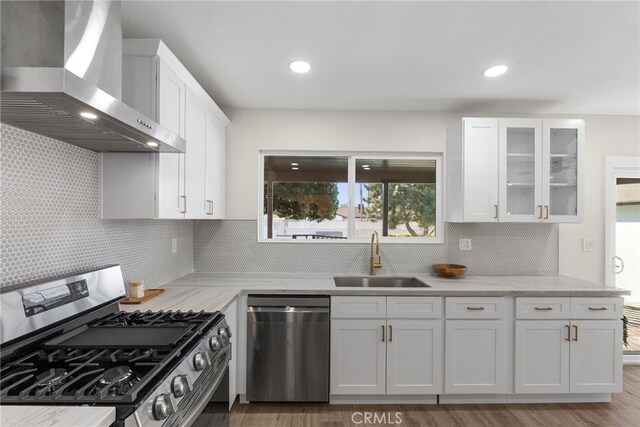16228 Plummer St, North Hills, CA 91343 - kitchen with appliances with stainless steel finishes, wall chimney range hood, white cabinetry, tasteful backsplash, and glass insert cabinets