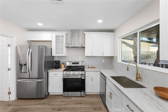 16228 Plummer St, North Hills, CA 91343 - kitchen featuring stainless steel appliances, wall chimney range hood, white cabinets, decorative backsplash, and glass insert cabinets