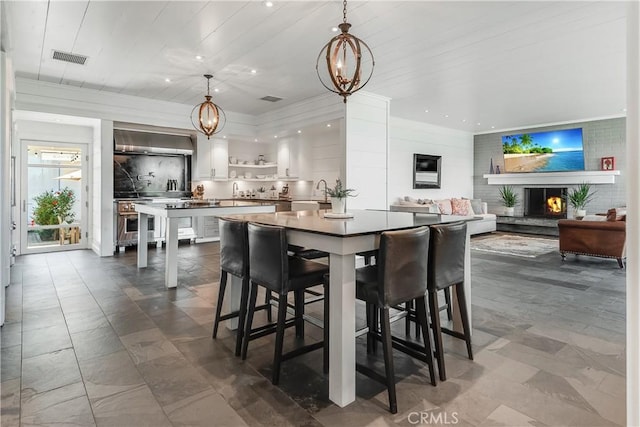 16 Roadrunner Rd, Rolling Hills, CA 90274 - dining space featuring a warm lit fireplace, crown molding, a chandelier, and recessed lighting