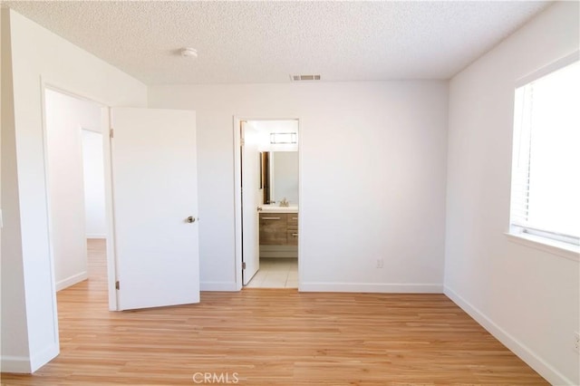 1714 Evelyn Pl, Palmdale, CA 93550 - unfurnished bedroom with light wood finished floors, a textured ceiling, and ensuite bath