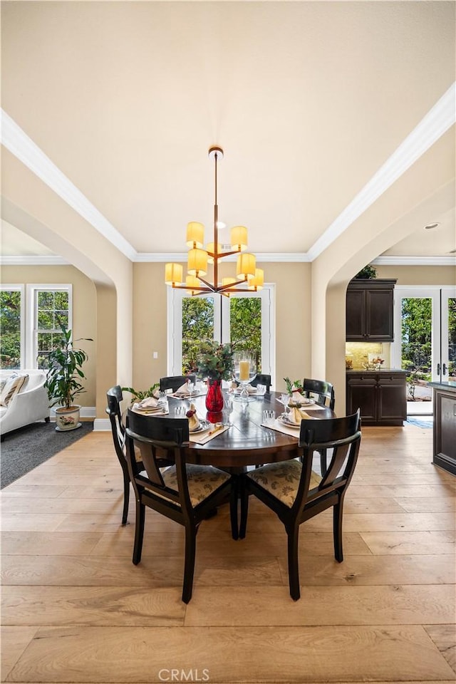 19668 Three Oaks Ln, Walnut, CA 91789 - dining area featuring arched walkways, a chandelier, light wood finished floors, plenty of natural light, and ornamental molding