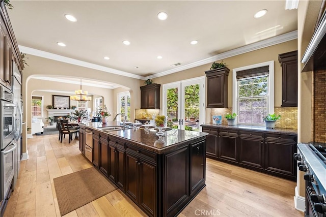 19668 Three Oaks Ln, Walnut, CA 91789 - kitchen featuring arched walkways, an island with sink, recessed lighting, tasteful backsplash, and stainless steel appliances