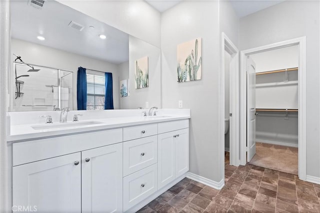16004 Huckleberry Ave, Chino, CA 91708 - bathroom with a stall shower, double vanity, a spacious closet, recessed lighting, and stone finish floors