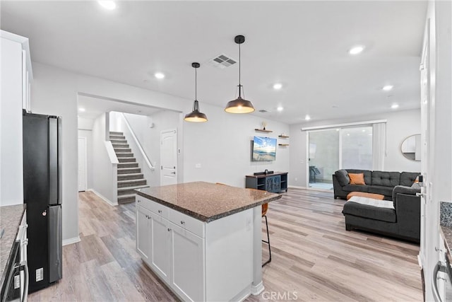 16004 Huckleberry Ave, Chino, CA 91708 - kitchen with freestanding refrigerator, white cabinets, a kitchen breakfast bar, light wood-type flooring, and recessed lighting
