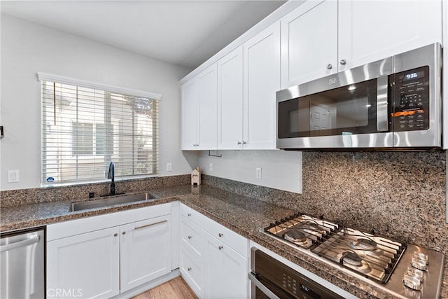 16004 Huckleberry Ave, Chino, CA 91708 - kitchen featuring stainless steel appliances, tasteful backsplash, white cabinetry, and dark stone counters