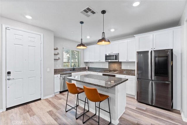 16004 Huckleberry Ave, Chino, CA 91708 - kitchen featuring stainless steel appliances, white cabinetry, a kitchen breakfast bar, light wood finished floors, and recessed lighting