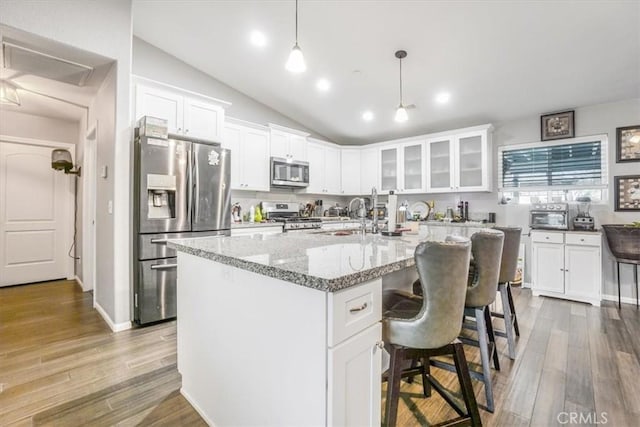 17993 Mondamon Rd, Apple Valley, CA 92307 - kitchen with appliances with stainless steel finishes, white cabinetry, glass insert cabinets, vaulted ceiling, and recessed lighting