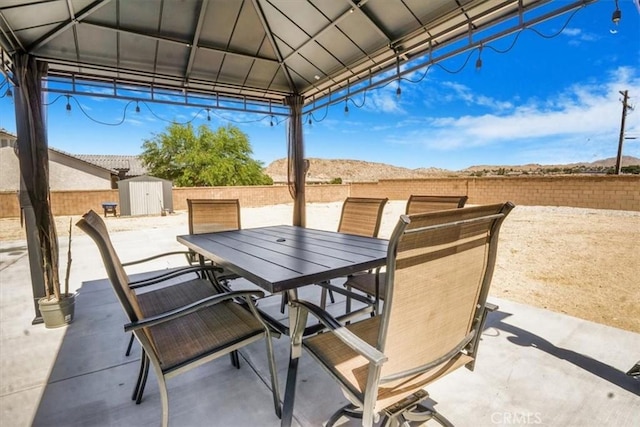 17993 Mondamon Rd, Apple Valley, CA 92307 - view of patio with outdoor dining space, a storage shed, and a gazebo