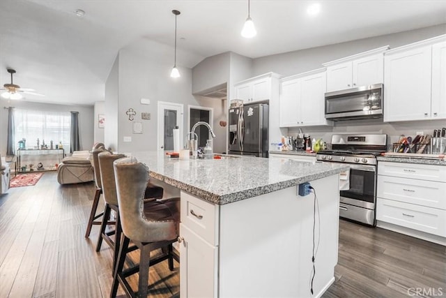 17993 Mondamon Rd, Apple Valley, CA 92307 - kitchen featuring appliances with stainless steel finishes, white cabinets, a center island with sink, ceiling fan, and open floor plan