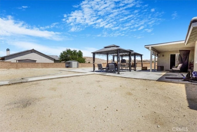 17993 Mondamon Rd, Apple Valley, CA 92307 - view of yard featuring a storage unit, a patio, and a gazebo