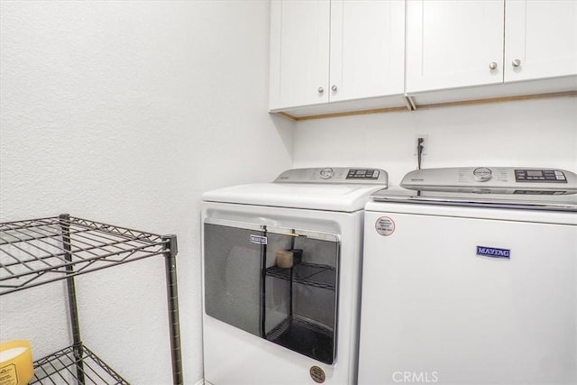 17993 Mondamon Rd, Apple Valley, CA 92307 - laundry area featuring washing machine and clothes dryer, cabinet space, and a textured wall