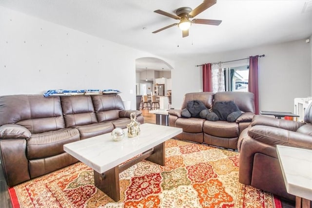 17993 Mondamon Rd, Apple Valley, CA 92307 - living area featuring arched walkways, ceiling fan, and light wood finished floors