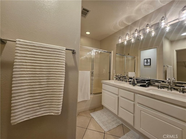 11 Emory Unit 85, Irvine, CA 92602 - full bath with tile patterned floors, double vanity, combined bath / shower with glass door, and a textured wall