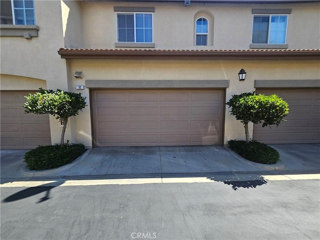 11 Emory Unit 85, Irvine, CA 92602 - view of front of home featuring stucco siding, an attached garage, and concrete driveway