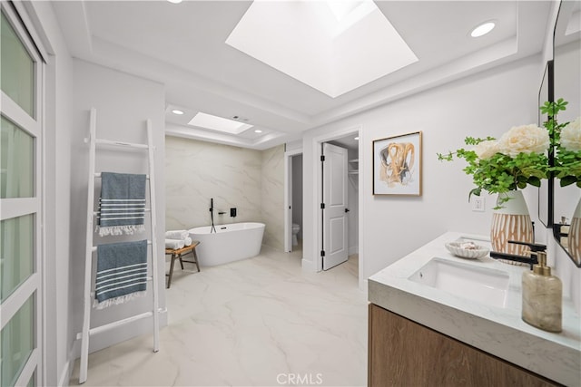 12 Creekside, Irvine, CA 92603 - bathroom featuring a skylight, a freestanding tub, marble finish floors, double vanity, and a tray ceiling