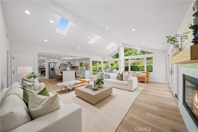 12 Creekside, Irvine, CA 92603 - living room with a glass covered fireplace, a skylight, light wood-type flooring, recessed lighting, and high vaulted ceiling