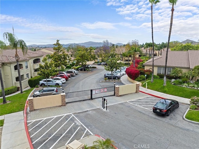 375 Central Ave Unit 196, Riverside, CA 92507 - uncovered parking lot featuring a gate, a mountain view, and a residential view