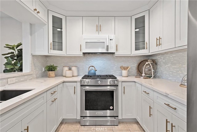 409 Utica Ave Unit C23, Huntington Beach, CA 92648 - kitchen featuring white microwave, stainless steel gas range, white cabinets, and light stone countertops