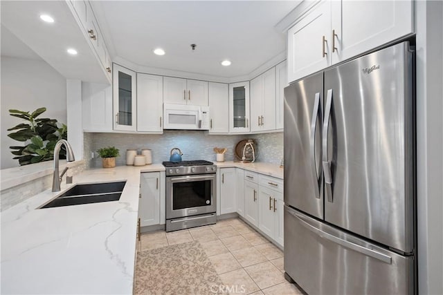 409 Utica Ave Unit C23, Huntington Beach, CA 92648 - kitchen featuring stainless steel appliances, light tile patterned floors, white cabinetry, light stone counters, and recessed lighting