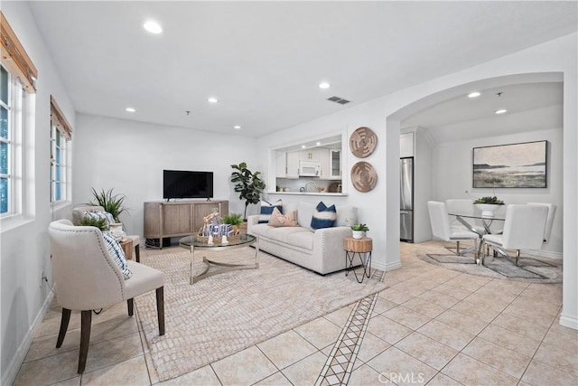 409 Utica Ave Unit C23, Huntington Beach, CA 92648 - living area featuring arched walkways, recessed lighting, and light tile patterned floors
