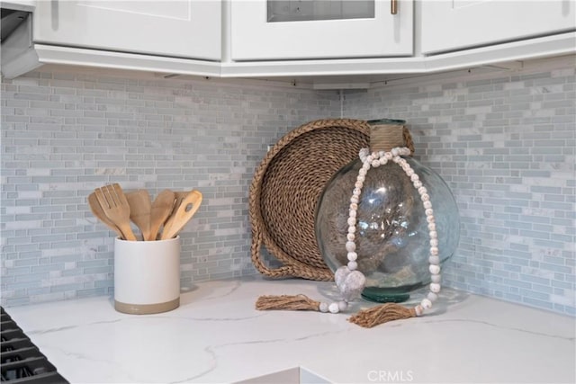 409 Utica Ave Unit C23, Huntington Beach, CA 92648 - kitchen view of light stone counters, backsplash, and white cabinetry