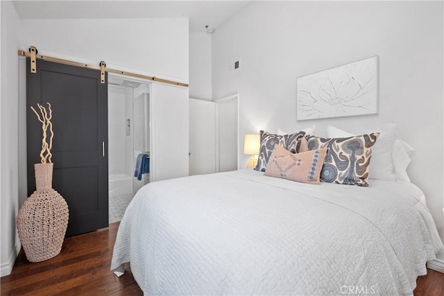 409 Utica Ave Unit C23, Huntington Beach, CA 92648 - bedroom featuring wood finished floors, a barn door, and high vaulted ceiling