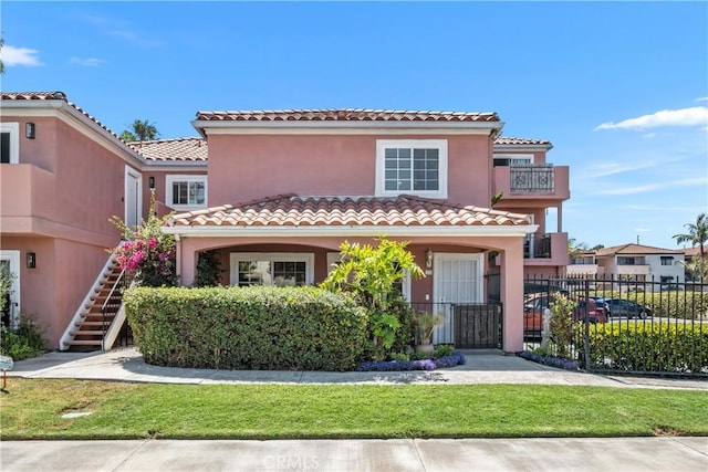 409 Utica Ave Unit C23, Huntington Beach, CA 92648 - mediterranean / spanish-style house with stairway, a tile roof, and stucco siding