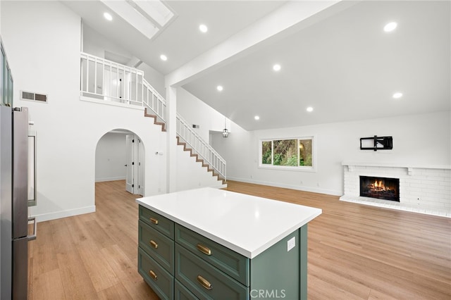 294 Calle Cuervo, San Clemente, CA 92672 - kitchen with green cabinets, freestanding refrigerator, a kitchen island, light wood finished floors, and arched walkways